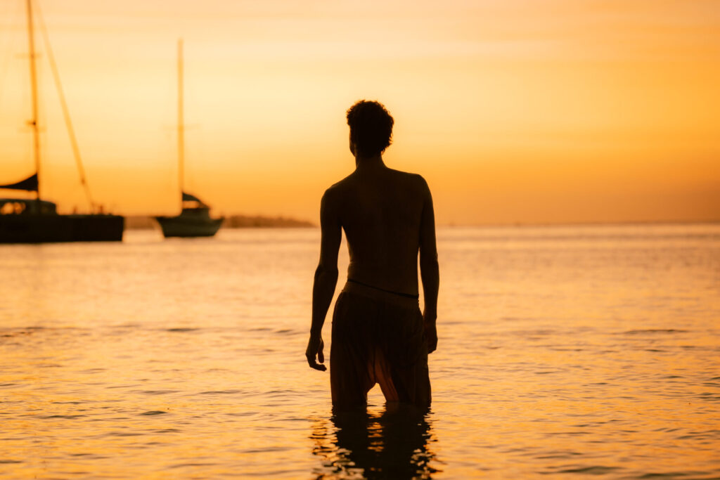 Mann steht bei Sonnenuntergang im Wasser – Sinnbild für Selbstfindung, Human Design Integration und innere Ausrichtung auf den eigenen Weg