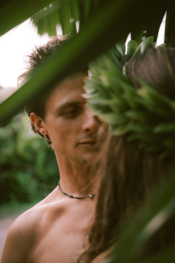 Bewusstes Paar im tropischen Grün – Mann und Frau blicken sich liebevoll an, Symbol für achtsame Verbindung und Frieden in Beziehung