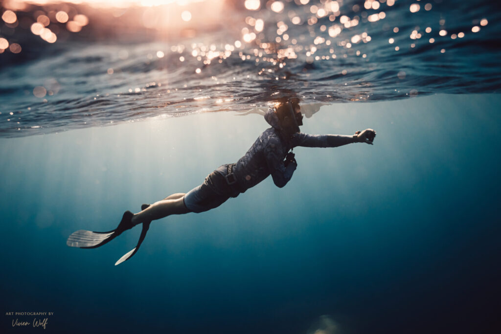 Schmerzillusion überwinden – Freediver gleitet kraftvoll durchs Wasser und recodiert seine DNA, um die Illusion des Leidens zu brechen.