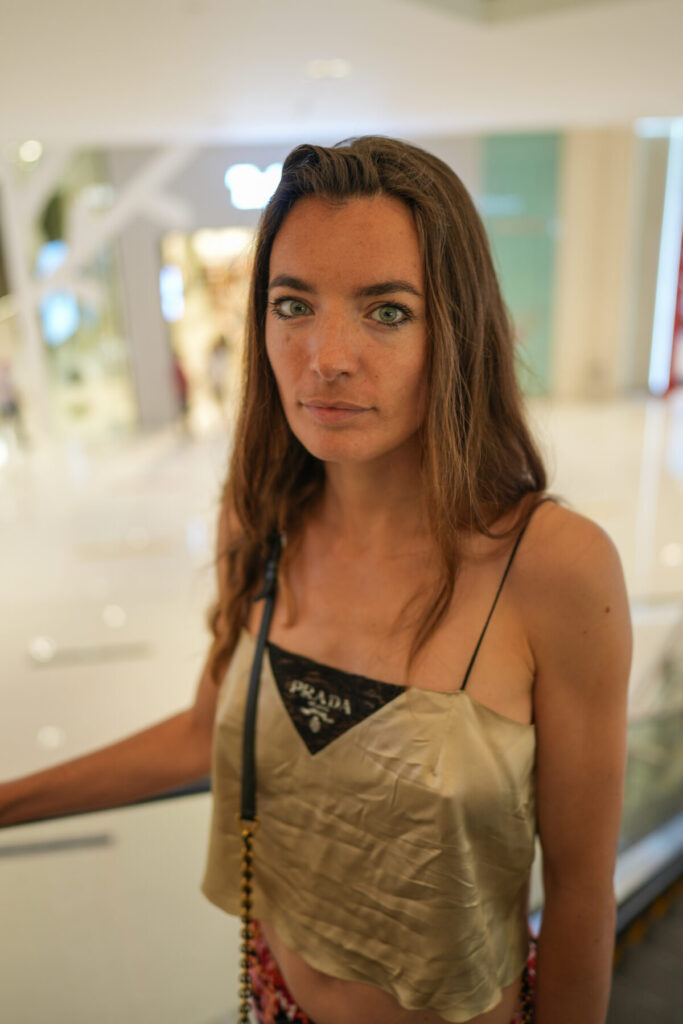 Entscheidung und Frequenz – Frau im goldenen Kleid blickt klar und offen in die Kamera, stille Präsenz, energetisches Potential in Verkörperung