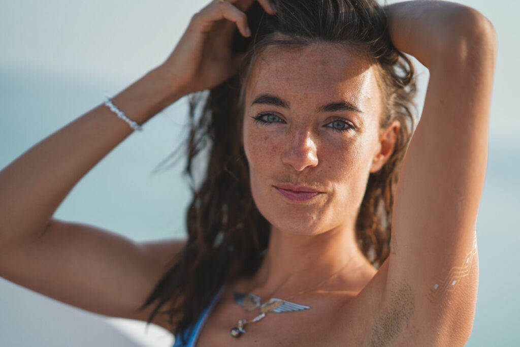 einzigartiges Design verkörpern: Frau im Sonnenlicht mit Hand im Haar zeigt klar ihr individuelles Torusfeld und die Einzigartigkeit ihres Human Designs.