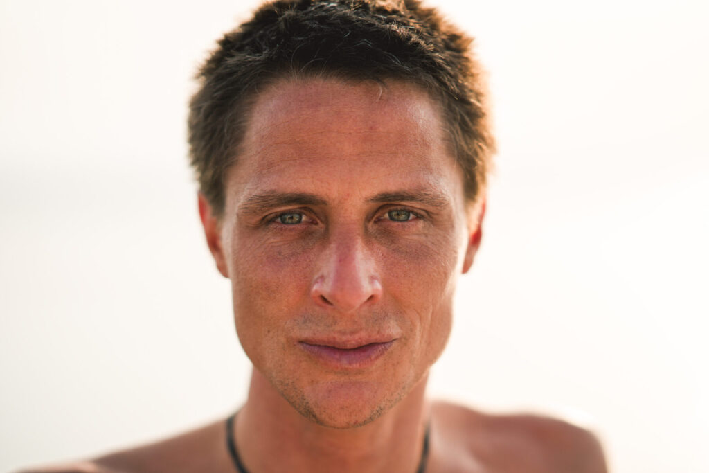 Porträt eines Mannes im warmen Sonnenlicht – klarer Blick, ruhige Stärke und Präsenz, Symbol für Liebe, Bewusstsein und Einheit