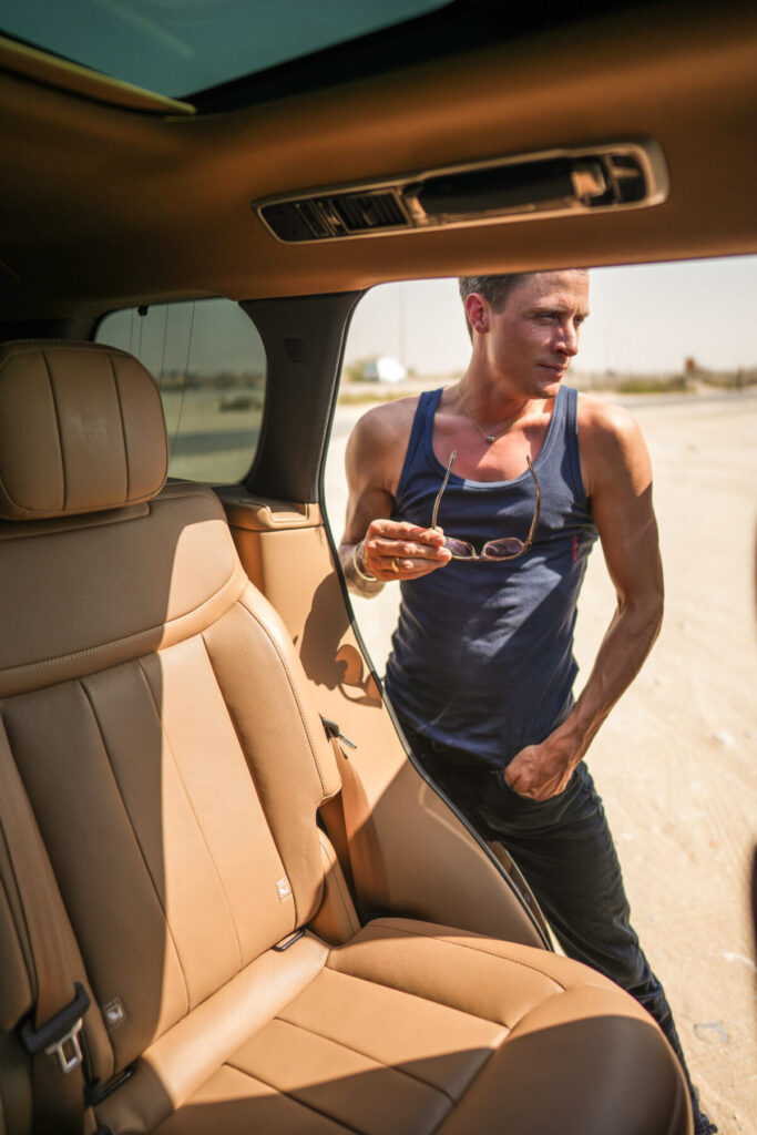 Mann steigt mit Sonnenbrille selbstbewusst aus dem Wagen, bereit für Action – Human Design, MG Dynamik, impulsives Voranschreiten