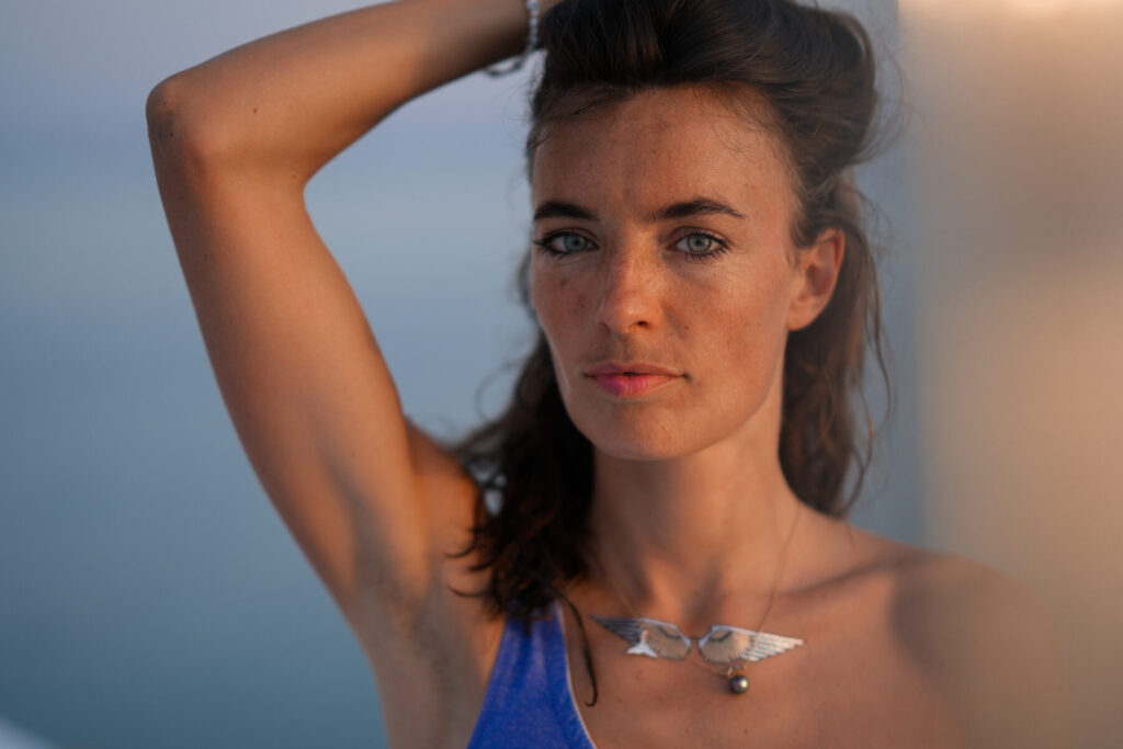 Erhöhte Schwingung und neues Bewusstsein – Frau mit offenem Blick am Meer bei Sonnenuntergang, Präsenz und Klarheit in tiefer Frequenz spürbar