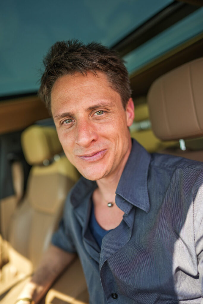 Eden Rückkehr – Mann im Auto lächelt, atmet bewusst und verkörpert „Grüsse aus Eden“ als Einladung zur Selbstwürdigung.