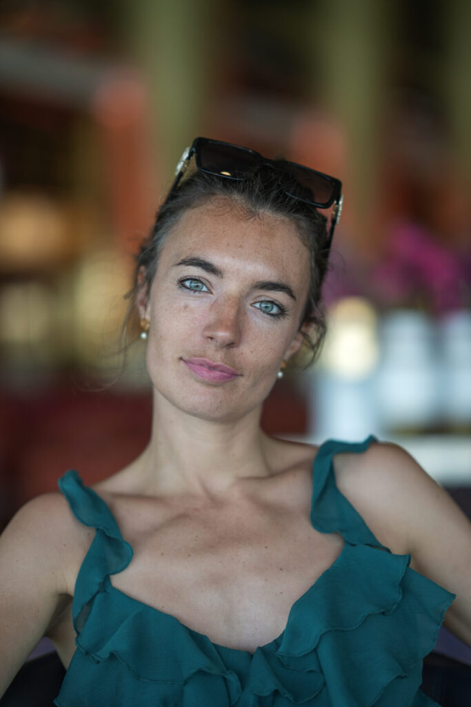 dem inneren Druck begegnen – Frau im Café, ruhiger Blick, grüne Träger, stille Präsenz, Selbstwahrnehmung, emotionale Klarheit