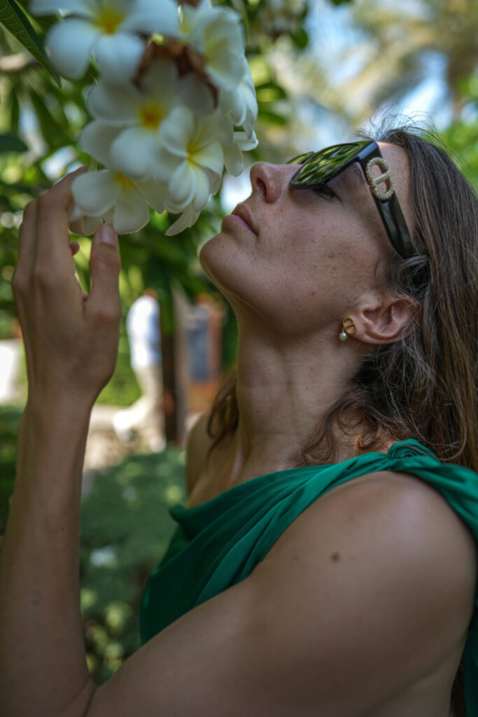 Frau riecht an weißer Blüte in der Natur – Human Design, 1/4 Profil, Verbindung zur Essenz, verkörperte Tiefe, stille Integrität.