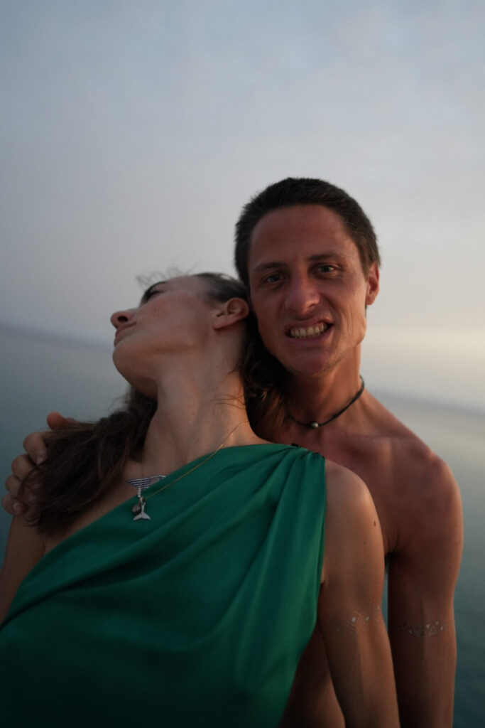 Liebe in Würde: Paar auf einem Boot im Abendlicht am Meer umarmt sich innig und verkörpert bewusste Liebe in Würde
