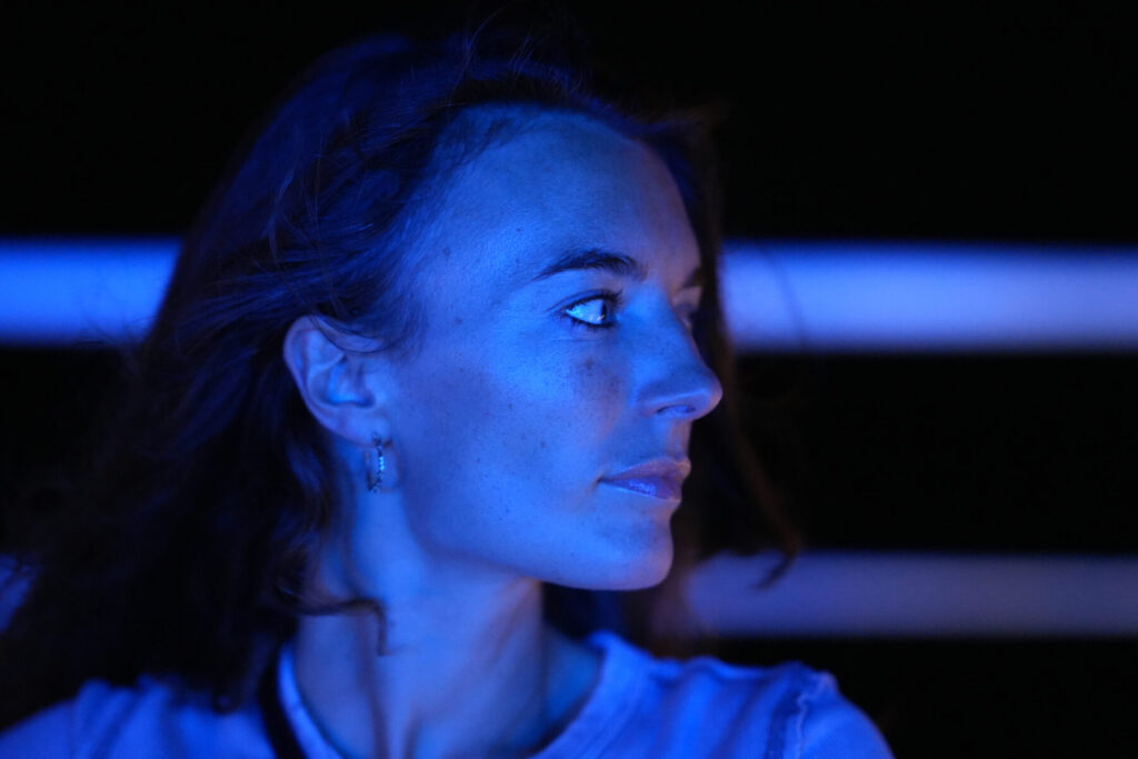 Vision im Übergang – Frau im blauen Licht mit ruhigem Blick zur Seite, Szene symbolisiert Klarheit, Hingabe und innere Ausrichtung