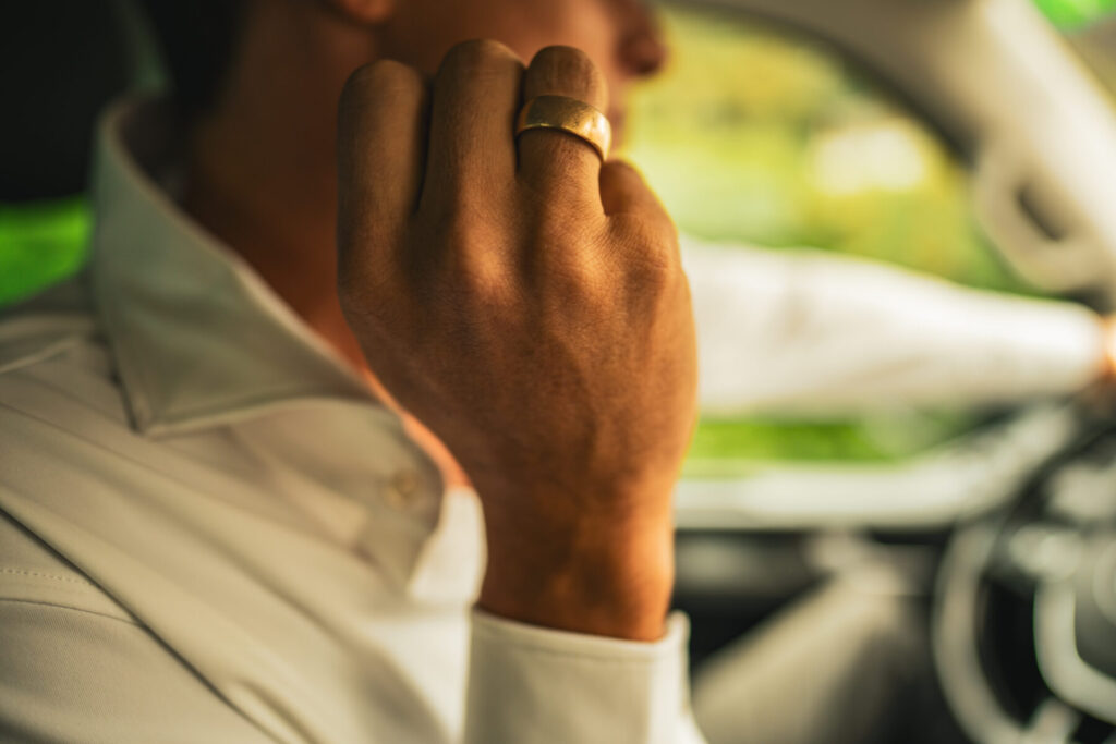 Business im Alltag – Mann im Auto mit Fokusblick beim Telefonat, symbolisiert Präsenz, Verantwortung und Gleichzeitigkeit von Rollen