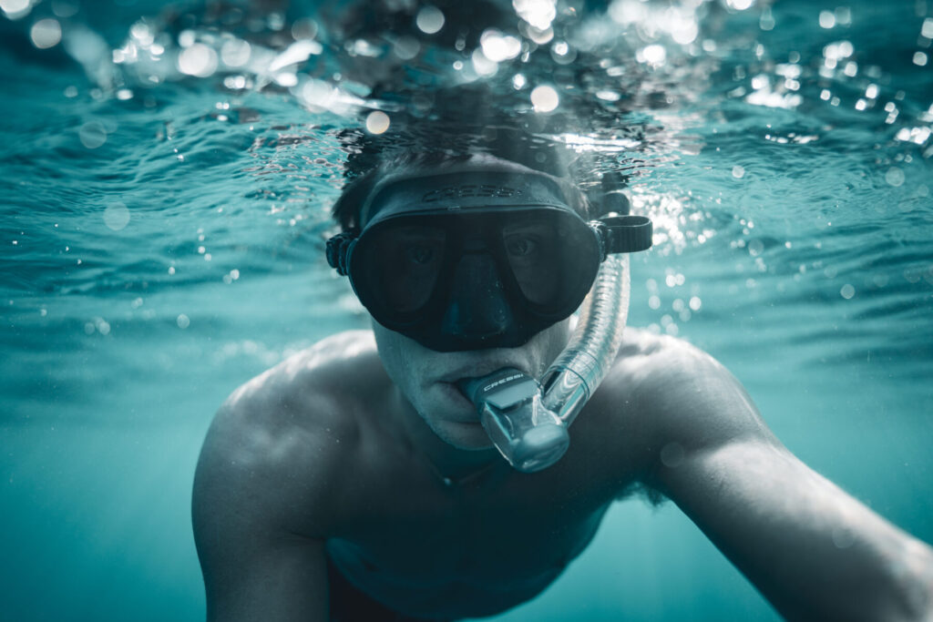 aus der Frequenz leben – Mann mit Tauchmaske taucht tief ins Meer, Konzentration und Stille im Wasser, Präsenz, Klarheit, Hingabe