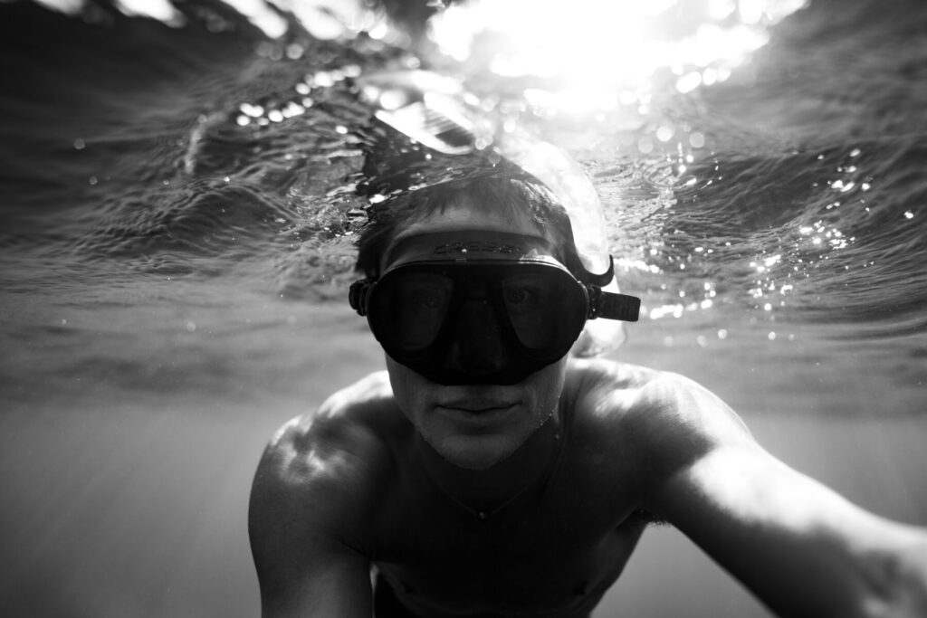 spirituelle Tiefe – Mensch taucht unter Wasser mit Blick nach innen, verbunden mit Stille, Einheit und der eigenen inneren Krone