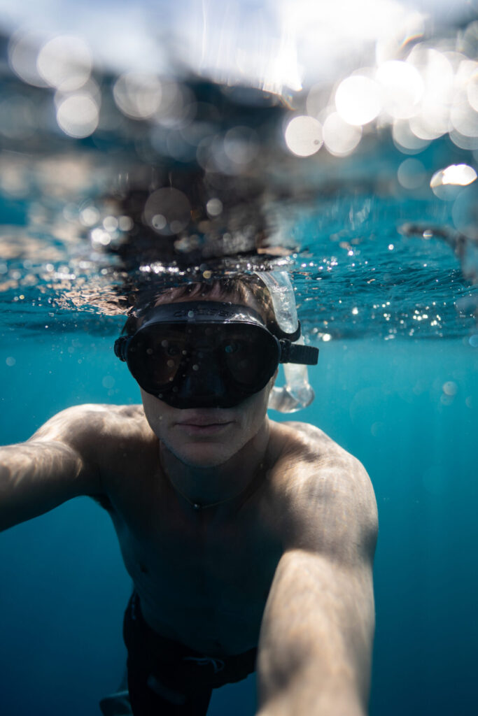 Delfinenergie spüren – Mann taucht unter Wasser mit Tauchermaske, Fokus, Ruhe und spielerischer Flow verbinden sich im Moment der Tiefe