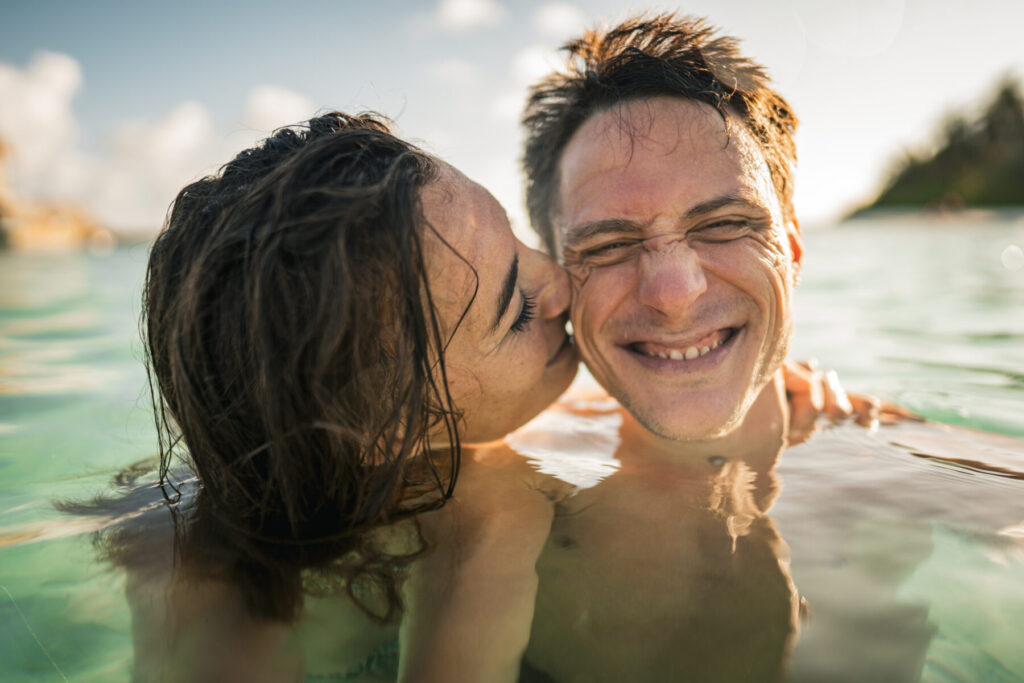 Lebensfreude und Verbindung im Wasser – ein Paar teilt Leichtigkeit, Nähe und pure Präsenz im Moment als Ausdruck bewussten, verkörperten Seins.