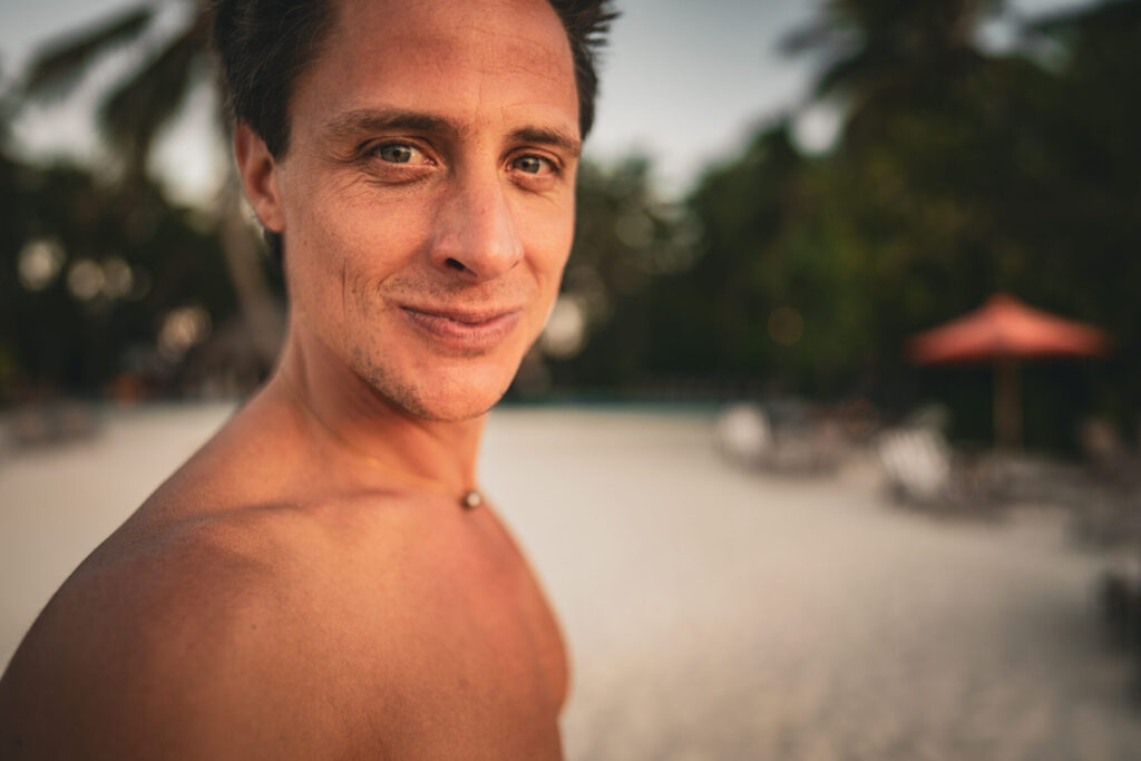 klare Entscheidung – Mann blickt lächelnd und atmet bewusst tief, Breathwork als Anker für emotionale Balance.