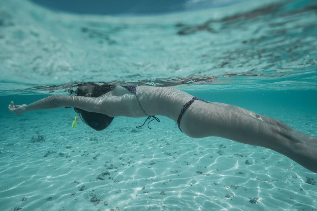 Yin Yang und Yun, verkörperte Leichtigkeit, Verbindung von Geist und Körper – Frau schwebt unter Wasser in klarem Pool