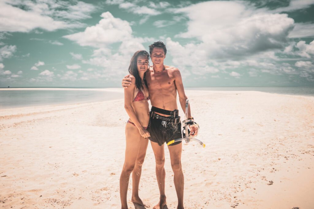 Synergien bündeln – Paar am Strand mit Taucherbrille und Sonnenlicht im Rücken zeigt Leader der Zukunft in geteilter Vision und kraftvoller Oneness.
