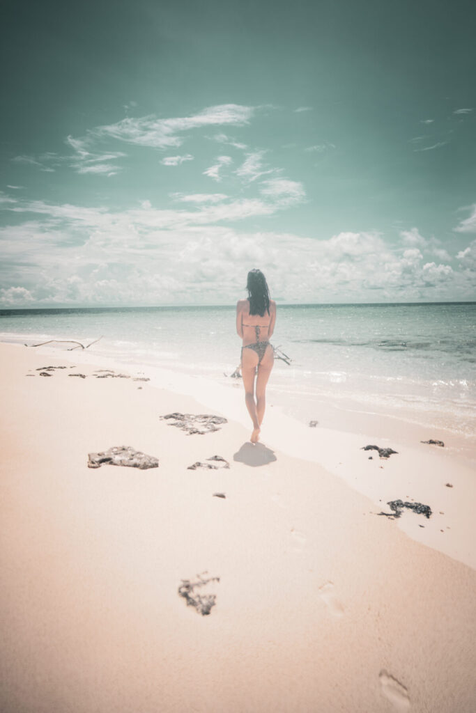 Stress regulieren mit Atemarbeit – Frau geht am leeren Sandstrand entlang, Symbol für Freiheit, Präsenz und innere Balance durch bewusste Atmung.