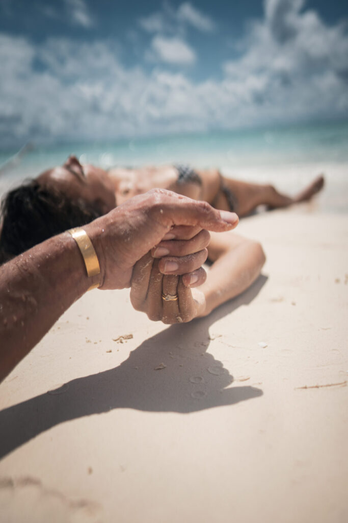 Paar hält sich an der Hand am Strand – Verbindung, Vertrauen und gemeinsamer Weg als Essenz für magnetisches Wachstum auf Instagram