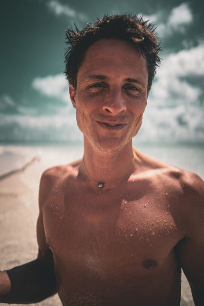 Klarheit und Ausstrahlung im Coaching Business – Mann mit offenem Blick am Strand, Symbol für Freiheit, Präsenz und verkörperte Sichtbarkeit
