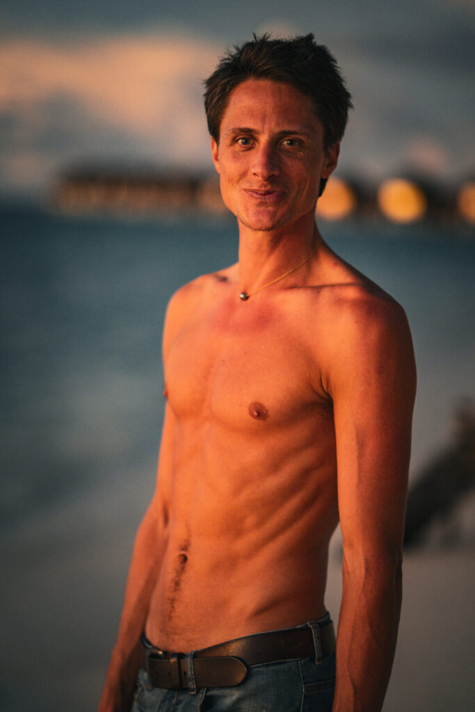 Hohe Frequenz spüren – Mann am Strand im Sonnenuntergang, offen, präsent, sein Blick trägt Weite, Leichtigkeit und stille Kraft