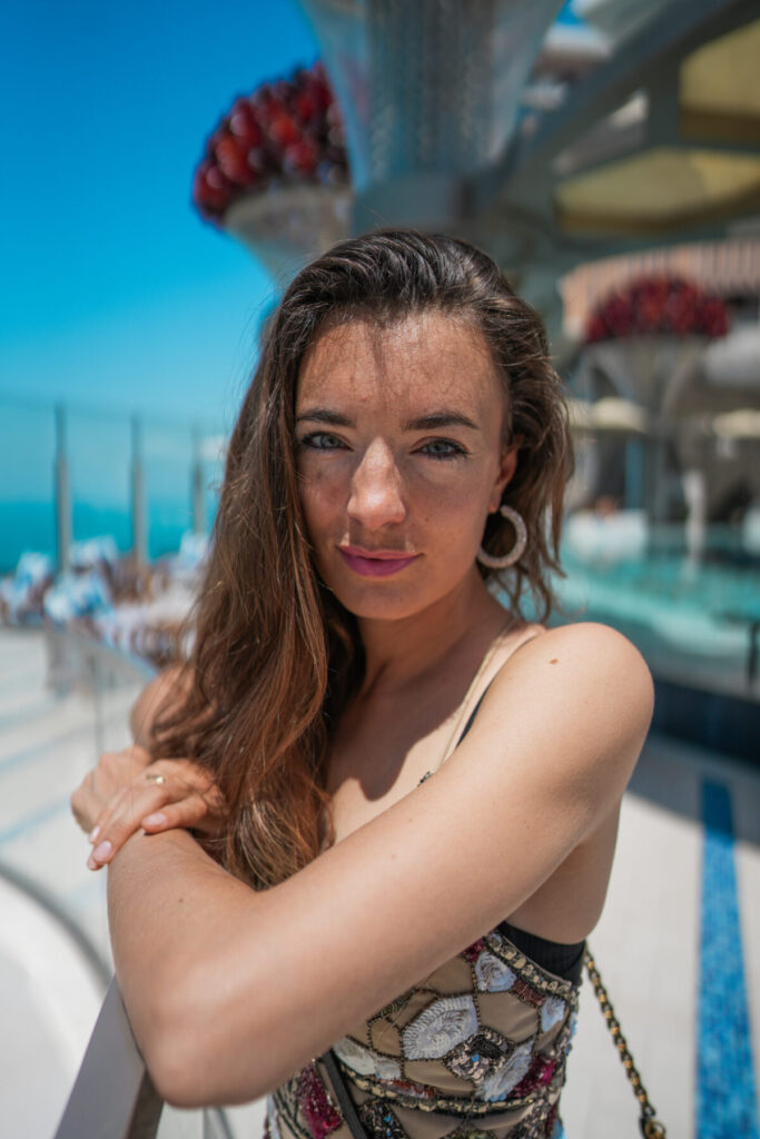 Frau mit langem Haar und offenem Blick am Pool – persönliche Freiheit, achtsames Reisen und nachhaltiger Delfinschutz