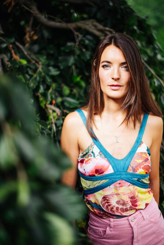 Frau im geblümten Kleid blickt ruhig in die Kamera – Human Design, Profil 4/1, Stabilität, Klarheit, Herzverbindung, innere Wahrheit