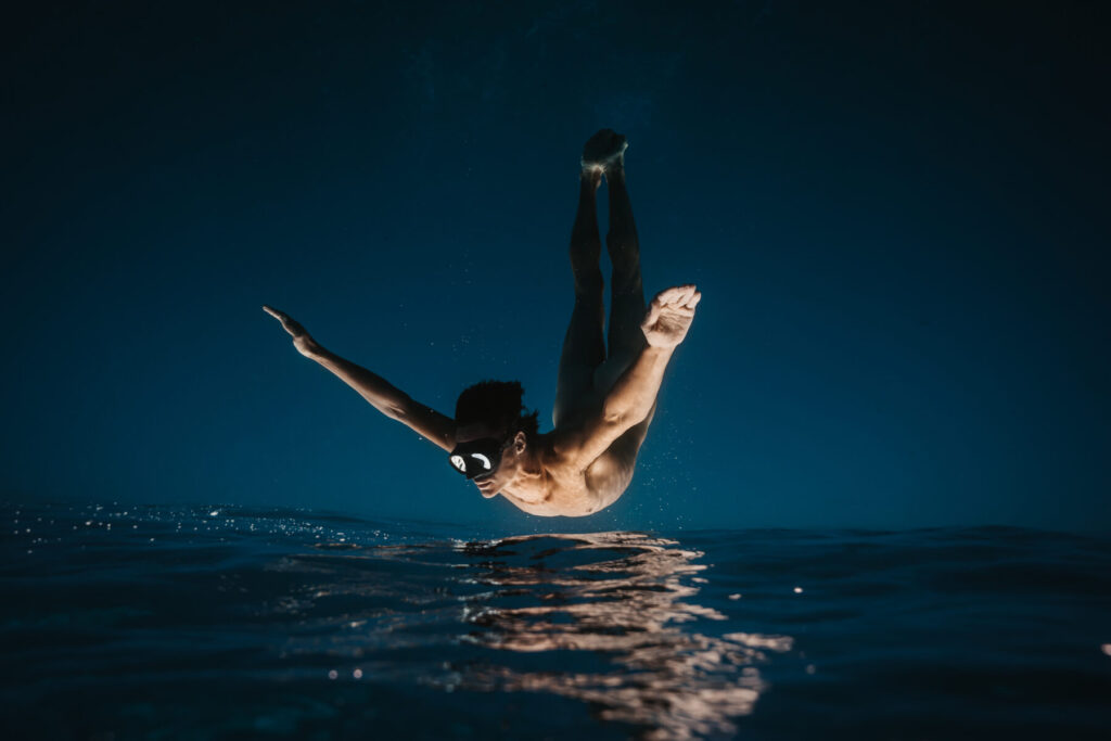 Breathwork online oder live – Mann taucht tief unter Wasser, symbolisiert innere Reise, Präsenz, Hingabe und sichere Tiefe im eigenen Atemraum