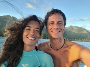strahlende Rückkehrer – Paar mit Nasstauchanzügen blickt leuchtend in Moorea und reflektiert die Präsenz der Wale in ihren Augen.