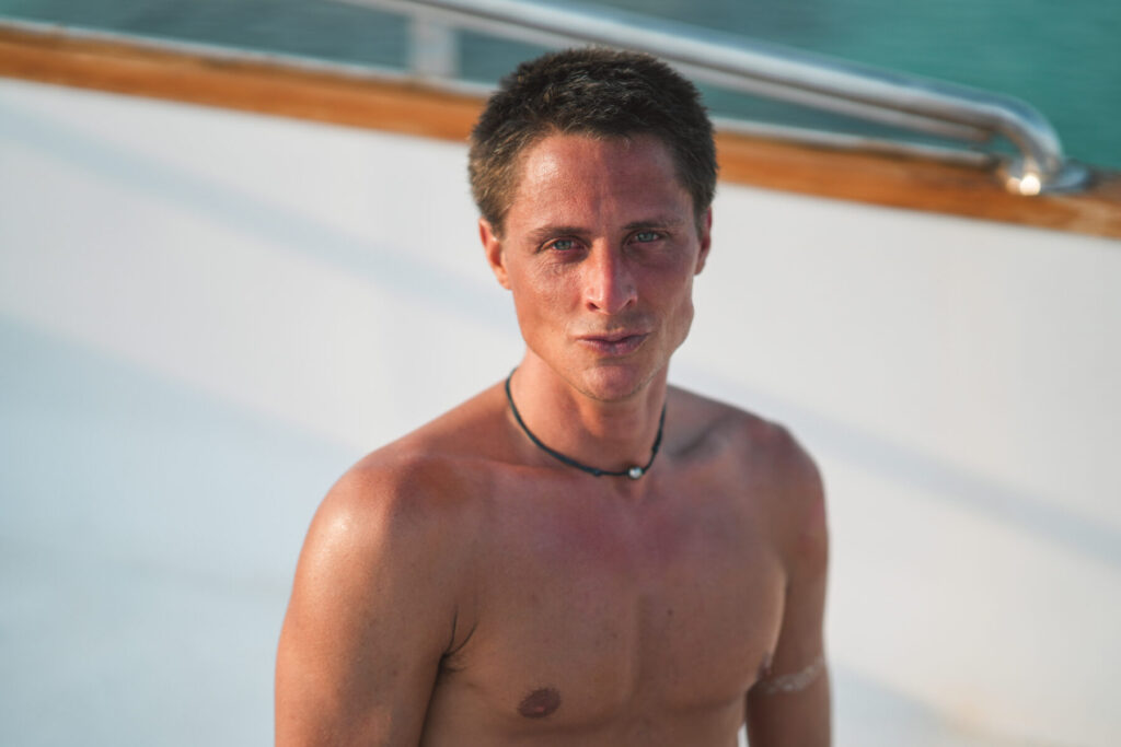 Selbstprojizierender Projektor im Human Design – Mann in der Sonne auf einem Boot verkörpert Klarheit, Wahrheit und die Kraft des eigenen Ausdrucks.